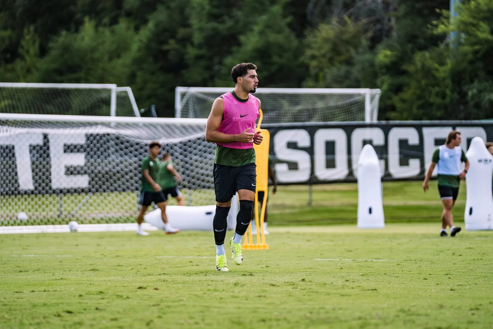 College soccer player jogging across the training pitch
