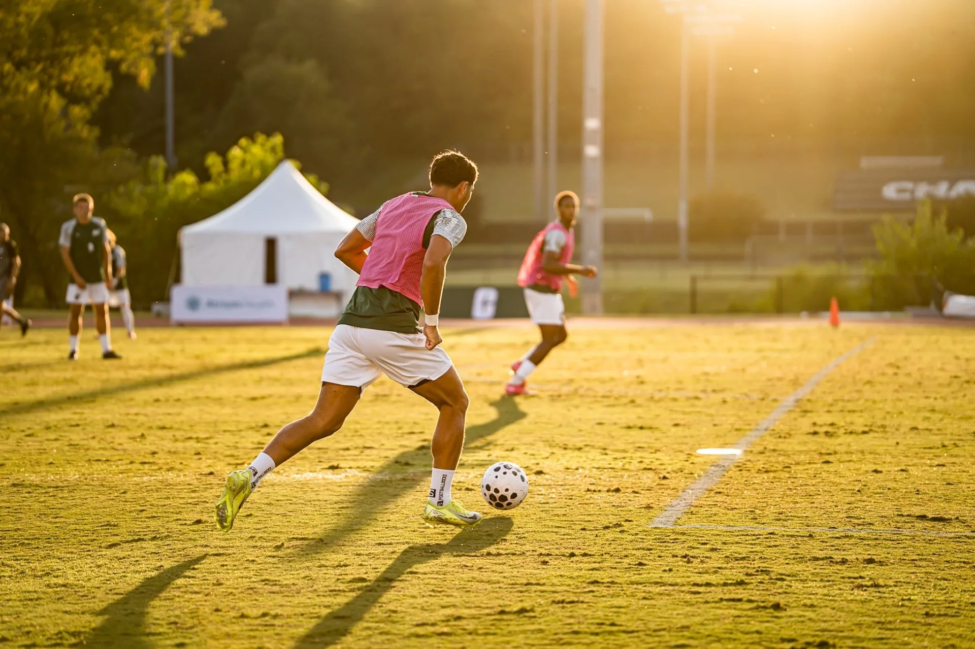 Player sprinting onto the ball at golden hour